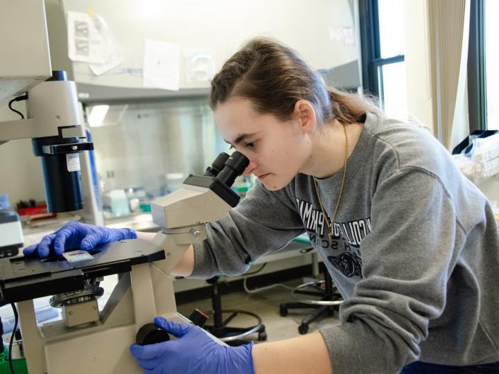 Erica looks into microscope